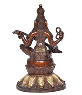 Saraswati idol from back view, seated on lotus holding veena and raised hands.