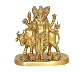 Brass Trimurti idol riding cow, layered robes, three-faced figures with raised symbols