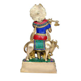 Rear view brass Krishna with cow idol, blue red green garments, flute in hand