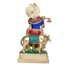 Rear view brass Krishna with cow idol, blue red green garments, flute in hand