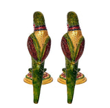 Front view of two iron parrot statues with green bodies, red bands, on gold bases