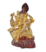 Maa Saraswati idol dorada con sitar y tocado rojo, enfoque en rostro y manos