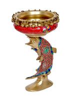 Brass urli bowl on fish decorative stand, red patterned body with blue trim