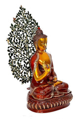 Golden Buddha statue in red robe, side pose, green leaf tree behind