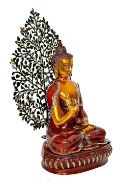 Golden Buddha statue in red robe, side pose, green leaf tree behind