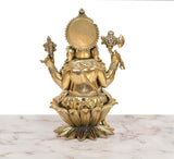 Back view of Lord Ganesha idol with round halo and raised arms over lotus base