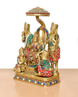 Brass Ram Darbar statue angled view: standing guards around central seated deity, colorful details