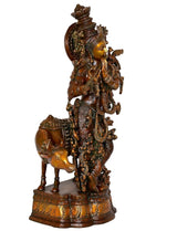 Krishna brass idol, rear side on decorated pedestal with cow beside him