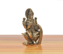 Bronze Lakshmi idol on lotus, 3/4 view with layered ornaments and seated pose