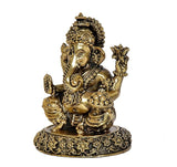 Brass Ganesha idol side view, four arms raised, decorative patterns on circular base
