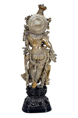 Brass Radha Rani idol with ornate back halo and crown, on dark carved pedestal