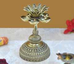 Brass lotus oil lamp diya with multi-petal top and ornate beaded base, close-up