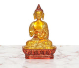 Brass Buddha idol seated in Abhaya mudra, golden robe and face, lotus pedestal