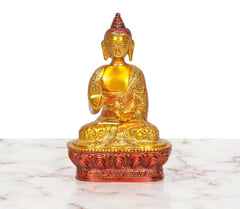 Brass Buddha idol seated in Abhaya mudra, golden robe and face, lotus pedestal