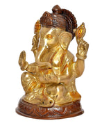 Brass Ganesha idol from side angle, seated with raised hands, ornate brown details
