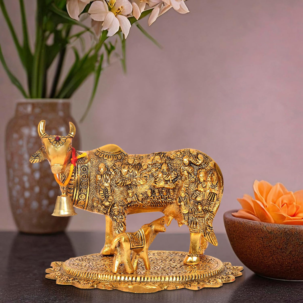 Metal Kamdhenu cow with calf statue, ornate gold finish, detailed reliefs and side bell