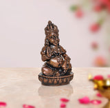 Copper Kuber statue, 2-inch three-quarter view, seated deity with crown and ornate base