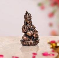 Copper Kuber statue, 2-inch three-quarter view, seated deity with crown and ornate base
