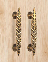 AONA brass leaf door handle pair, golden, two vertical bars on light wood