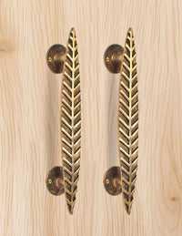 AONA brass leaf door handle pair, golden, two vertical bars on light wood