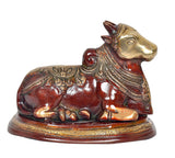 Side view Nandi bull statue, gold-toned head, red body with engraved decorative band