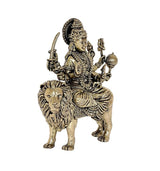 Durga Maa brass statue on lion, raised hands holding items, angled view