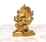 Brass seated Lord Ganesha statue, golden finish, profile view with ornate crown