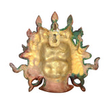 Brass Mahakala wall hanging mask back, textured gold-toned surface with green patches