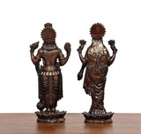 Back view of brass Lakshmi and Vishnu idols with textured garments and crown