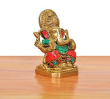 Brass Ganpati Bappa idol angled view; red, green and gold attire