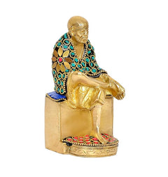 Brass Shirdi Sai Baba statue idol, angled view with gold base and colorful trim