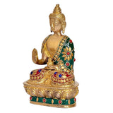 Brass Buddha statue side view with jeweled green robe, raised hand and lotus base, 7.5 in.