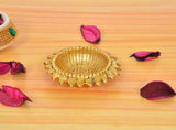 Golden metal oil diya lamp with decorative scalloped outer rim and wick in center