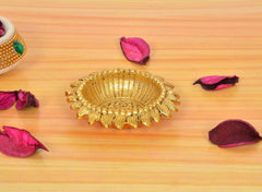 Golden metal oil diya lamp with decorative scalloped outer rim and wick in center