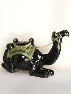 Sitting camel sculpture, front angle: black camel with green saddle and gold rope