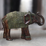 Large brass elephant standing sculpture, three-quarter view, green patina armor and flared trunk