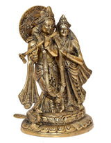 Brass Radha Krishna idol statue, angled view with detailed jewelry and halo back