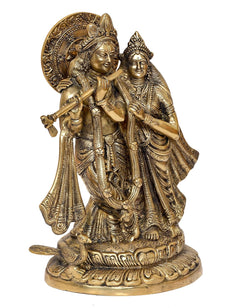 Brass Radha Krishna idol statue, angled view with detailed jewelry and halo back