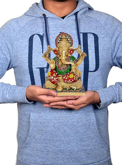 Messing-Ganesha-Statue wird in den Händen gehalten, vierarmig mit bunten Verzierungen