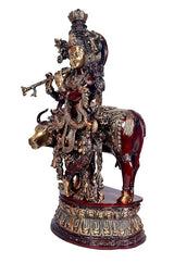 Brass Krishna riding cow murti, front-side view, maroon cow body and ornaments