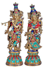 Brass Radha Krishna sculpture, twin standing figures with gold detailing and red teal attire