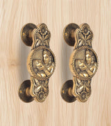 Golden brass door handle pair, curved backplates and two-god & goddess relief medallions