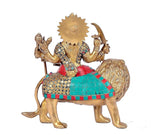 Brass Durga statue on lion, teal and red dress with gold sun halo