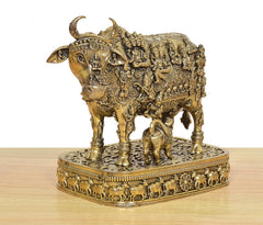 Side view of Kamdhenu cow and calf murti, ornate bronze pedestal with relief animals