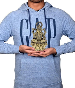 Brass Ganesha idol (6 inch) held in hands, showing lotus base and crown