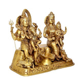 Golden brass Shiv Parivar idol angled view: Shiva with staff and Parvati beside him