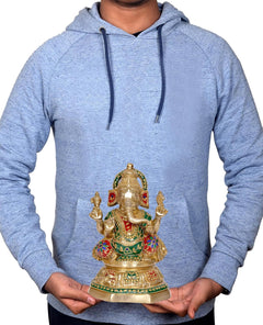 Brass Ganesha idol held in hands for scale, seated pose with painted ornaments