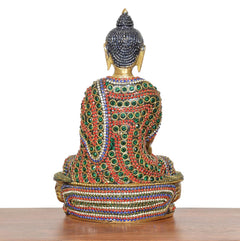 Rear view of brass-tone meditating Buddha statue with multicolored jeweled robe