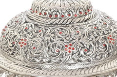 Close-up of silver carved chatta dome with embossed floral vines and red inlay dots