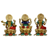 Back view of brass Ganesha, Lakshmi and Saraswati idols on lotus bases, teal and red